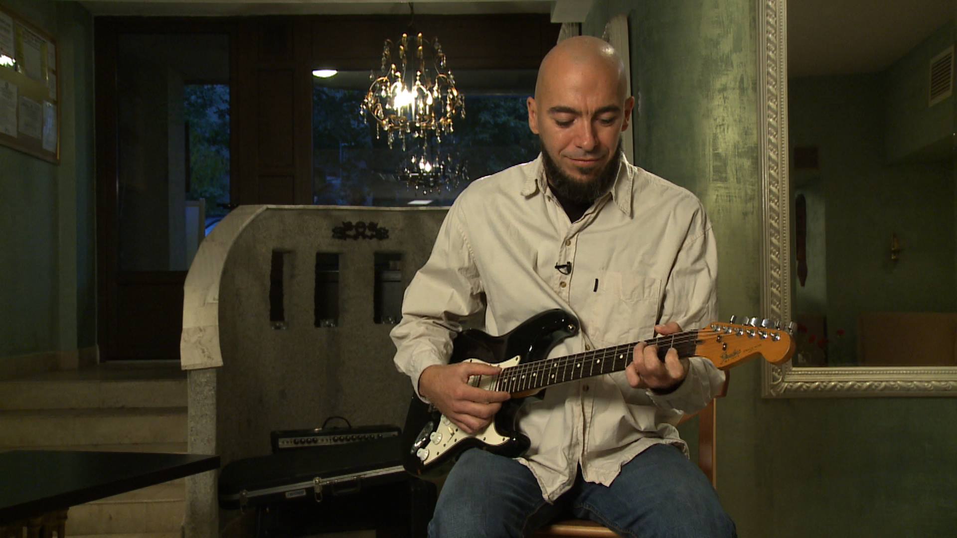 Cyfer playing Stratocaster seated